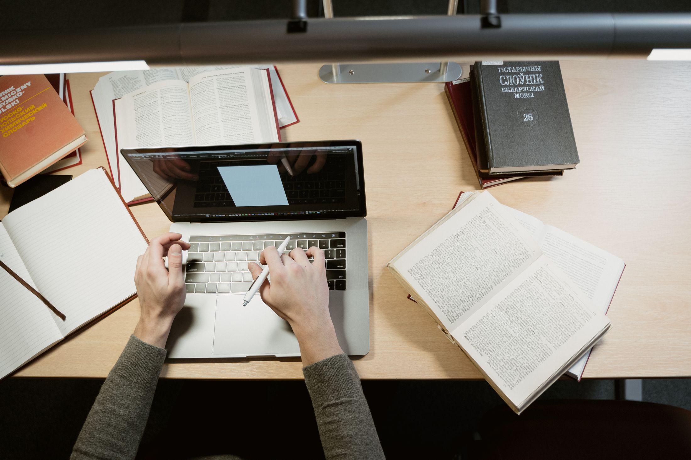 Student organising research notes beside a laptop